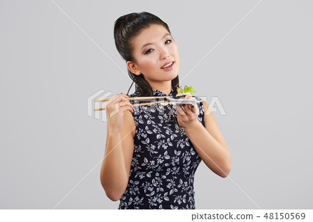 Sushi woman holding sushi with chopsticks Sushi woman holding sushi with chopsticks 48150569