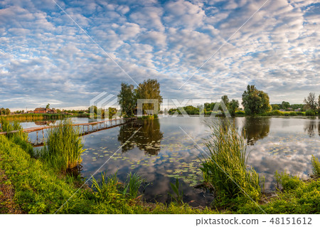 Small House with Trees on Island at Lake 48151612