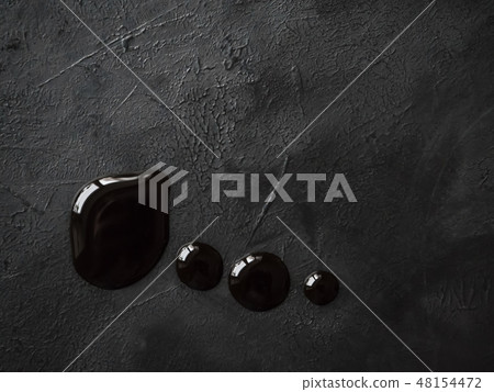 Puddle of soy sauce on a black table. Close up. Puddle of soy sauce on a black table. Close up. 48154472