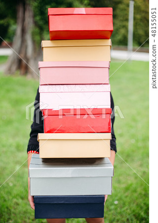 Unrecognizable girl with stack of shoe boxes over Unrecognizable girl with stack of shoe boxes over 48155051