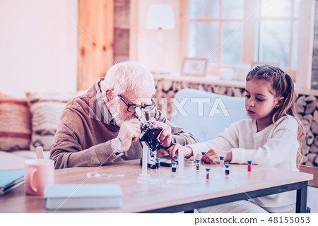 Grey-haired man watching in modern small microscope Grey-haired man watching in modern small microscope 48155053