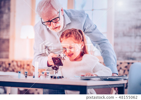 Schooler blinking while using microscope sitting at desk Schooler blinking while using microscope sitting at desk 48155062