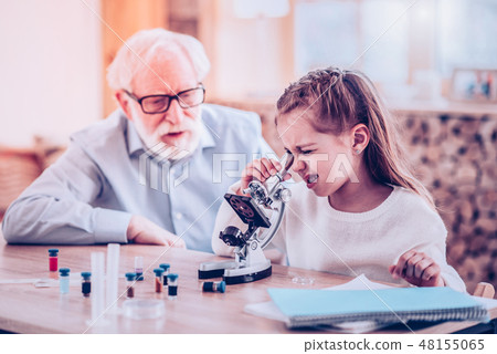 Girl watching in microscope during private lesson Girl watching in microscope during private lesson 48155065