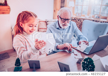 Girl playing constructor with her grandfather at home Girl playing constructor with her grandfather at home 48155127