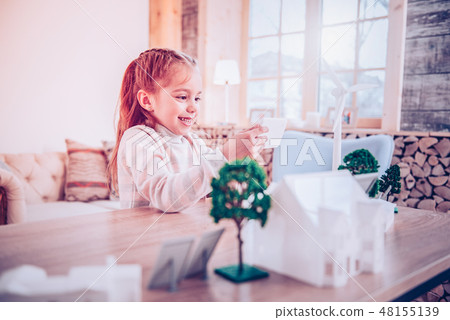 Smiling kid showing working windmill her parents Smiling kid showing working windmill her parents 48155139