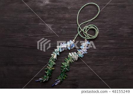 A multi-colored beads on a green rope A multi-colored beads on a green rope 48155249