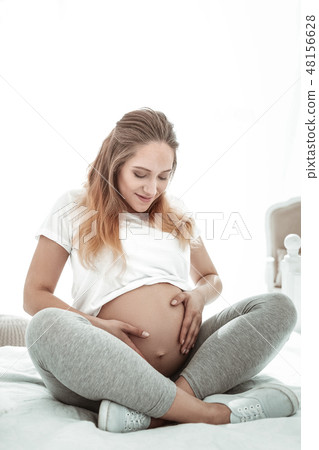 Positive pleasant lady sitting with crossed legs and observing 48156628