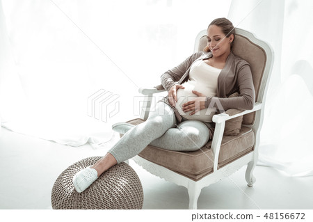 Smiling good-looking woman touching her pregnant belly Smiling good-looking woman touching her pregnant belly 48156672
