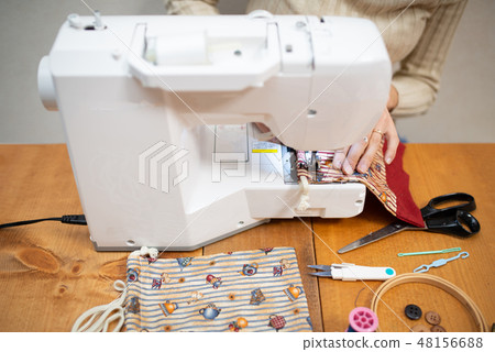 A woman operating a sewing machine A woman operating a sewing machine 48156688