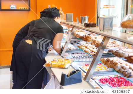 Tray of eclairs on pastry shop counter. Tray of eclairs on pastry shop counter. 48156867