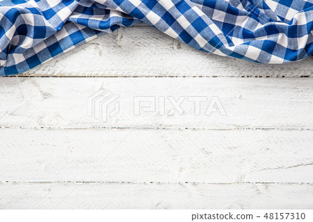 Blue checkered kitchen tablecloth on wooden table. 48157310