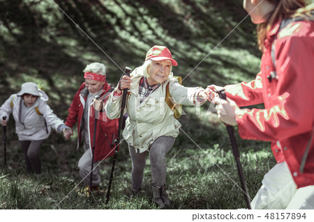 Fashionable old folk having Nordic walking in forest 48157894
