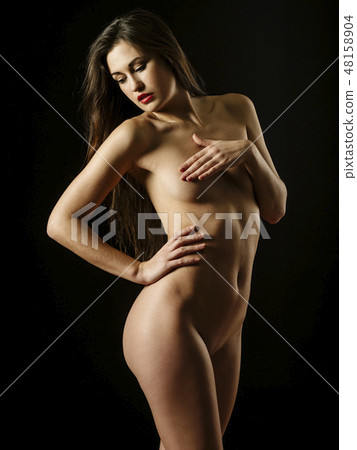 Nude woman standing over dark background 48158904