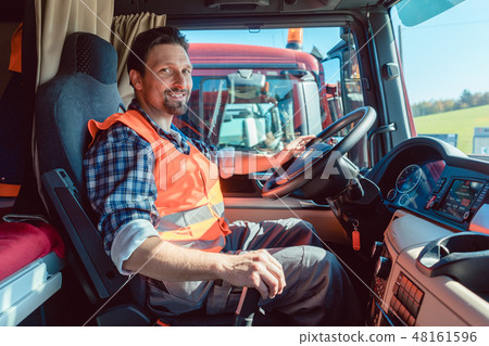 Lorry or truck driver sitting in the cabin of his vehicle 48161596