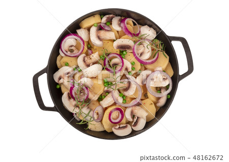 A photo of a braiser with raw vegetables, potatoes, onions, green peas, mushrooms, and rosemary 48162672