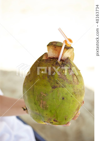 Woman's hand with coconut juice palm nats summer image Woman's hand with coconut juice palm nats summer image 48163734