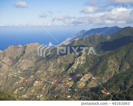 view point Amogoje, green hills with rock in the sea El Draguillo in anaga mountain, tenerife canary view point Amogoje, green hills with rock in the sea El Draguillo in anaga mountain, tenerife canary 48163863