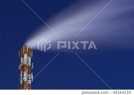 Night picture of a steaming pipe of smoking factory chimney system against a dark starry sky 48164239