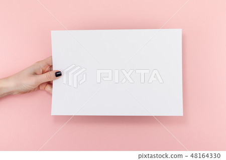 Woman hands with blank A4 paper sheet mockup Woman hands with blank A4 paper sheet mockup 48164330