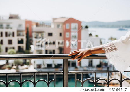 black brides hand railing terrace overlooking sea 48164547