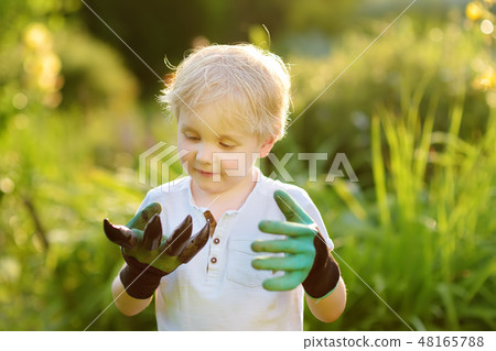 Little boy wearing garden gloves having fun Little boy wearing garden gloves having fun 48165788