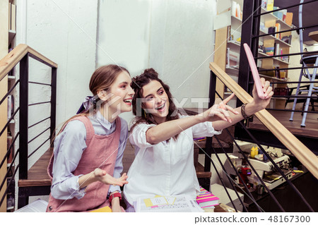 Active young dark-haired lady raising her hand with tablet Active young dark-haired lady raising her hand with tablet 48167300