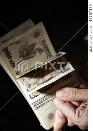 一個女人的手數一百萬日元鈔票 一個女人的手數一百萬日元鈔票 48167329