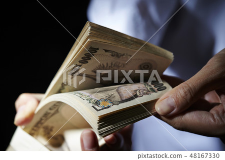 A woman's hand to count one million yen notes A woman's hand to count one million yen notes 48167330