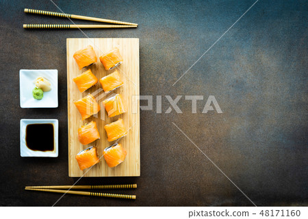Salmon fish meat sushi roll maki on wood plate 48171160