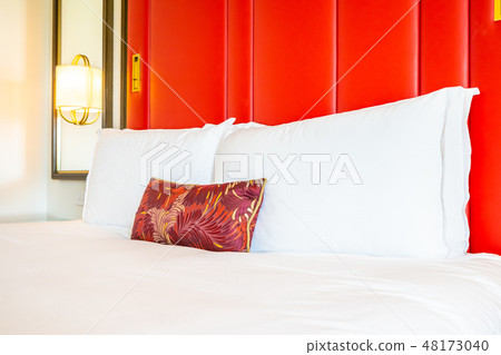 Comfotable pillow on bed with light lamp decoration 48173040