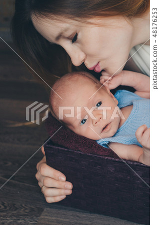 baby in the arms of the mother. 48176253