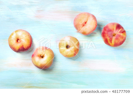 An overhead photo of vibrant organic flat saturn peaches, shot from above on a teal background with An overhead photo of vibrant organic flat saturn peaches, shot from above on a teal background with 48177709