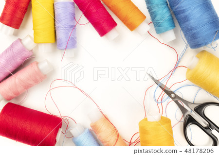 Overhead photo of threads and scissors on white, forming frame for copy space Overhead photo of threads and scissors on white, forming frame for copy space 48178206