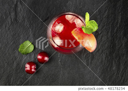 Overhead photo of a vibrant red drink with cherries on black Overhead photo of a vibrant red drink with cherries on black 48178234