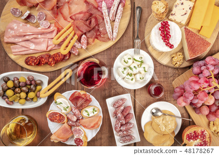 Charcuterie Tasting. Many different sausages and hams, deli meats, and a cheese platter, shot from 48178267
