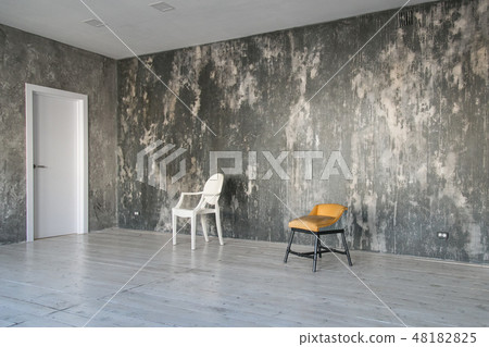 Modern light loft-style room with designer chairs and lighting. Gray walls with the texture of the Modern light loft-style room with designer chairs and lighting. Gray walls with the texture of the 48182825