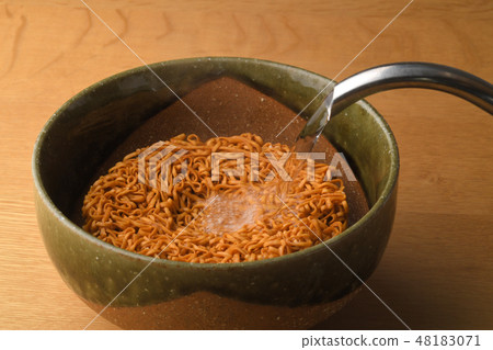 Pour hot water into instant noodles 48183071