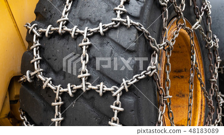 Front loader for snow removal with metal snow chains on wheels. Snow removal in the mountains. 48183089