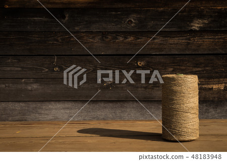 A roll of twine on a wooden background. Selelective focus. Close-up. Free space for text. A roll of twine on a wooden background. Selelective focus. Close-up. Free space for text. 48183948