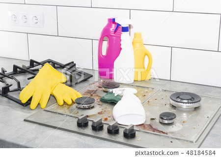 Cleaning a gas stove with kitchen utensils,  48184584