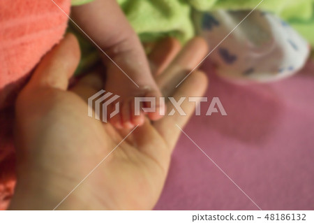 Blurred baby feet on the hands of the mother Blurred baby feet on the hands of the mother 48186132
