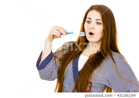 Woman holds toothbrush with paste. Woman holds toothbrush with paste. 48186284