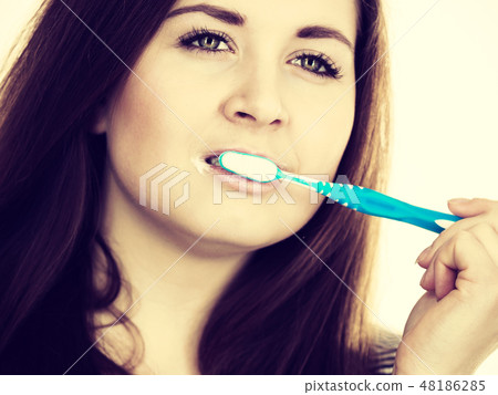 Woman brushing cleaning teeth. 48186285