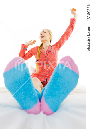 Woman in pajamas wearing furry warm socks 48186286