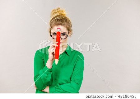 Woman confused thinking, big pencil in hand 48186453