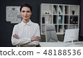 Businesswoman standing, office interior on background, female. 48188536