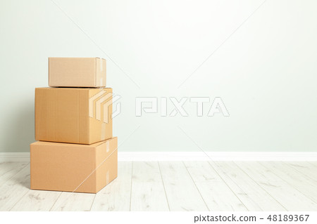 Day moving. Delivery of goods, shopping. Cardboard boxes on gray wall background. Copy space for 48189367