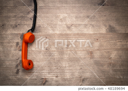 Phone receiver hanging down on a cord Phone receiver hanging down on a cord 48189694