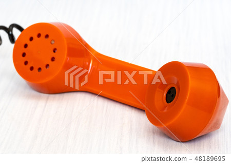 Orange phone receiver close-up 48189695