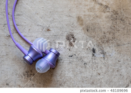 Earphones on old canvas background 48189696